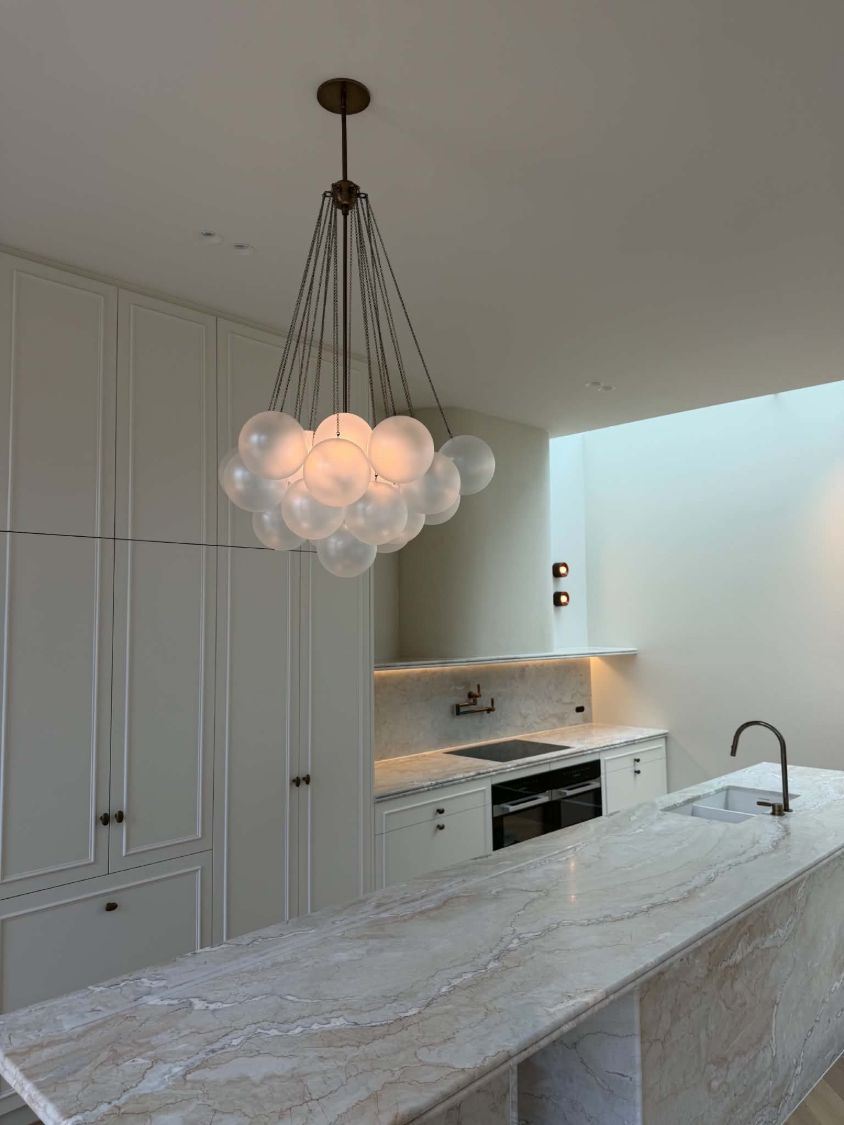 Frosted glass cluster pendant above a marble kitchen island