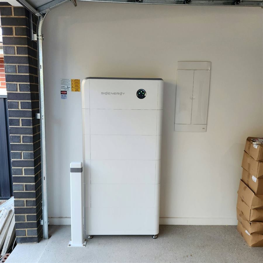 Sigenergy home battery mounted on a garage wall beside the switchboard